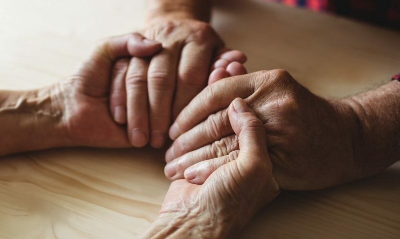 old people holding hands